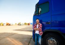 truck driver in a red shirt with blue truck in the background