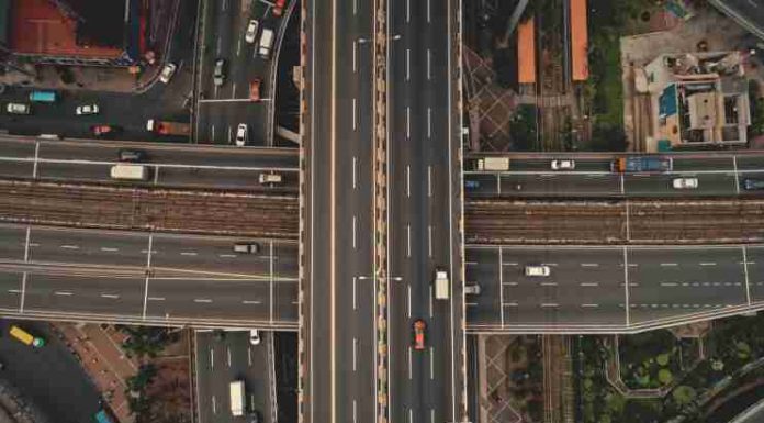 Top down cross traffic highway with cars, trucks aerial. Urban transportation at bridge road at city