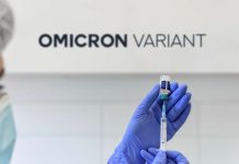 Medical worker holding syringe and examining a patient of Omnicron