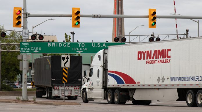 Transport trucks pass under a "Bridge To USA" at the entrance to the Ambassador Bridge, US-Canada border crossing. (Windsor, Ontario)