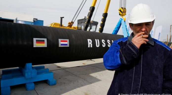 A Russian construction worker smokes in Portovaya Bay, Russia, during a ceremony marking the start of Nord Stream pipeline construction