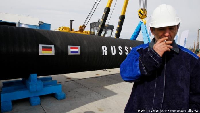 A Russian construction worker smokes in Portovaya Bay, Russia, during a ceremony marking the start of Nord Stream pipeline construction