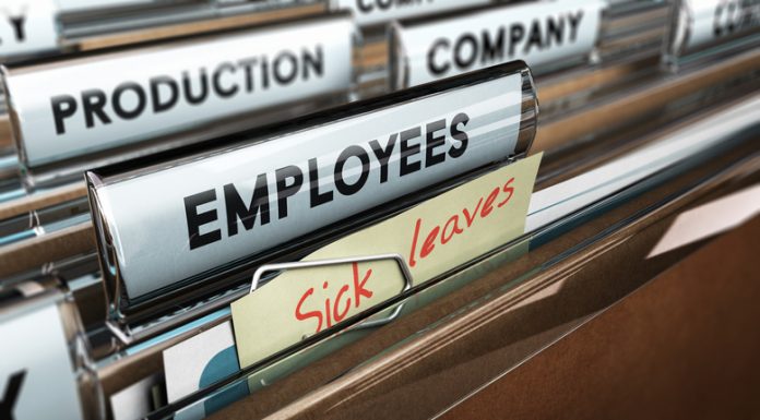 Close up on a file tab with the word employees plus a note with the text sick leaves, blur effect at the background. Concept image for illustration of sick leave entilement.