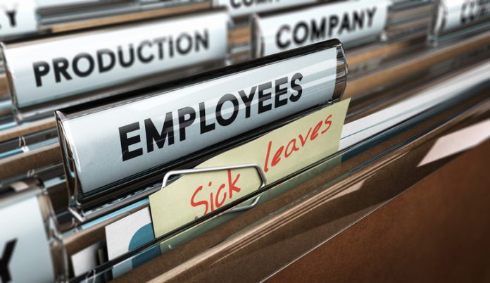 Close up on a file tab with the word employees plus a note with the text sick leaves, blur effect at the background. Concept image for illustration of sick leave entilement.