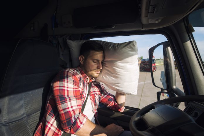 Truck driver sleeping in his truck.
