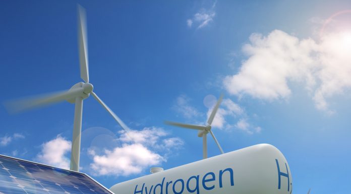 Hydrogen tank, solar panel and windmills on blue sky background. Sustainable and ecological energy concept.