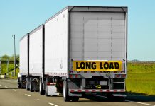 When semi-trucks reach a certain length they are required to attach hazard signs such as long load.