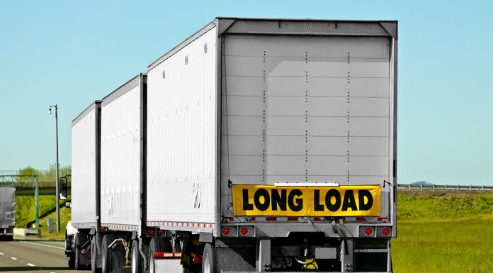 When semi-trucks reach a certain length they are required to attach hazard signs such as long load.